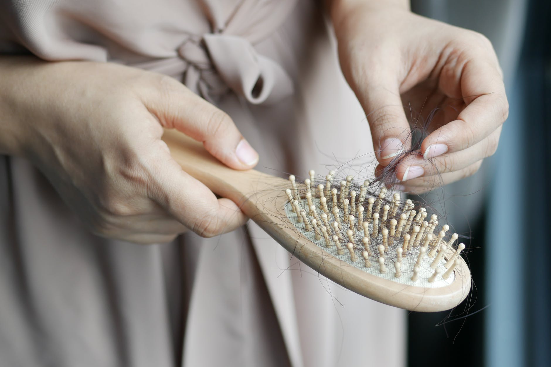 a woman removing hair from a hair brush
