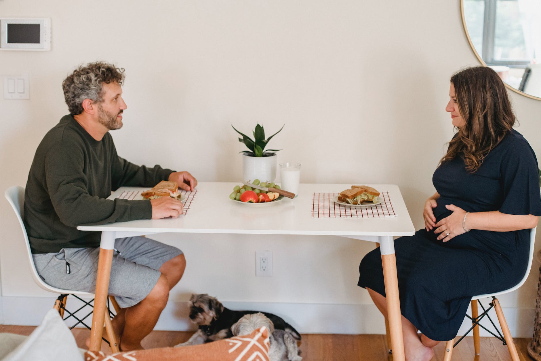 happy couple eating sandwiches at breakfast in cozy apartment